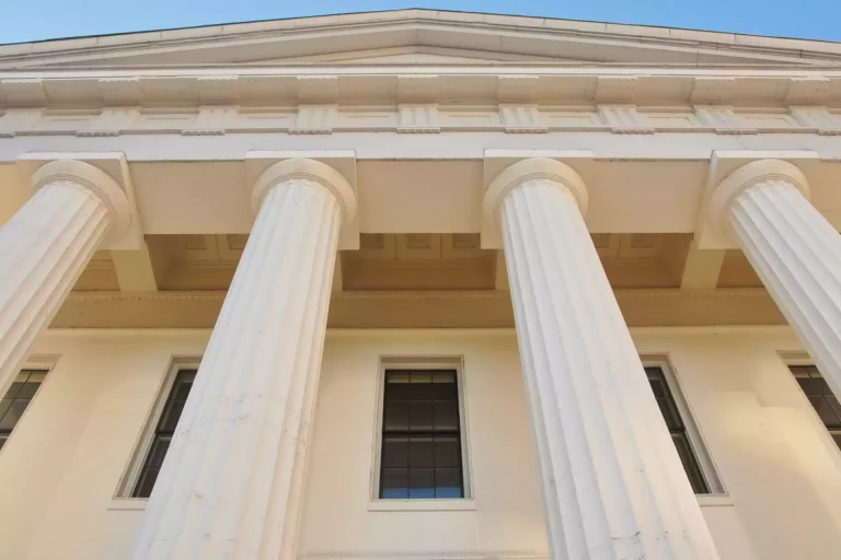 Façade imposante d'un bâtiment de justice avec des colonnes doriques, symbolisant la solidité et l'intégrité en audit et contentieux commercial.