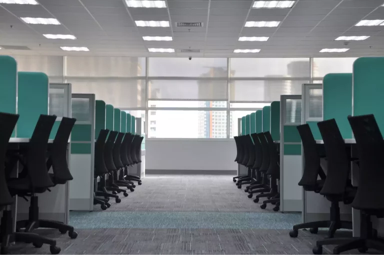 Bureaux d'entreprise vides avec des chaises ergonomiques et des cloisons, prêts pour les professionnels, reflétant l'expertise du cabinet spécialisé en droit social.