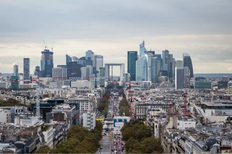 Vue aérienne du quartier d'affaires de Paris, montrant des bâtiments modernes et historiques, symbolisant l'expertise en baux et transactions immobilières.
